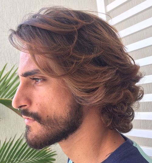 Long textured waves hairstyle with natural wavy movement and layered styling for men