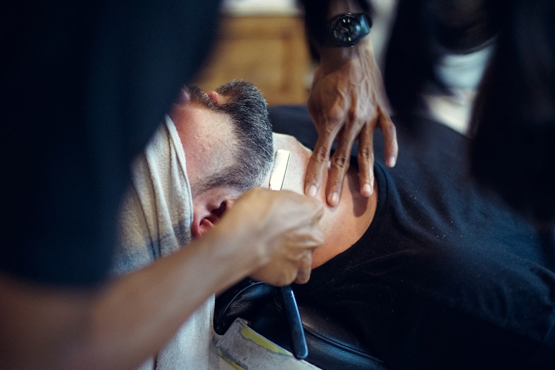 Professional barber providing expert low fade haircut service demonstrating value of quality barbering in Queens NYC