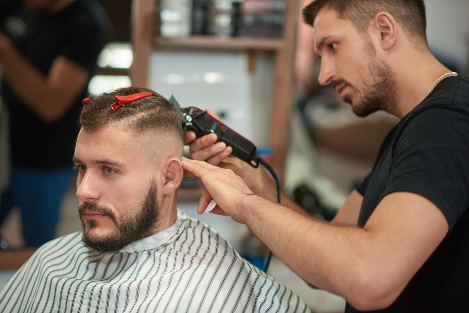 Professional low fade haircut demonstration showcasing expert barbering techniques and precision cutting methods at modern barbershop in Queens NYC