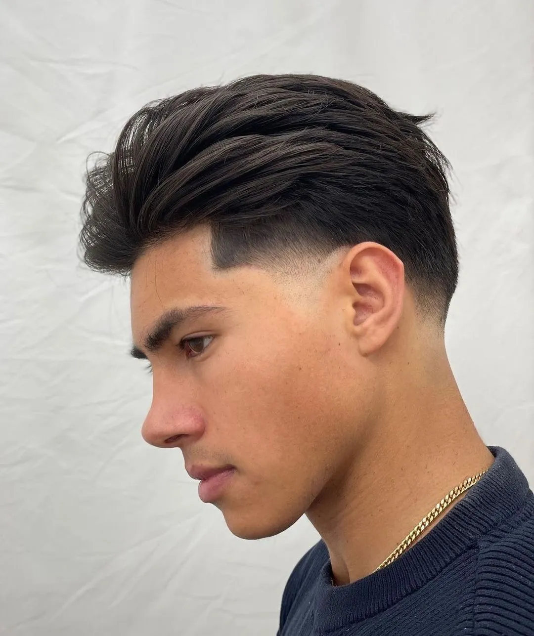 Slick back hairstyle with relaxed pomade finish showing professional styling at barbershop