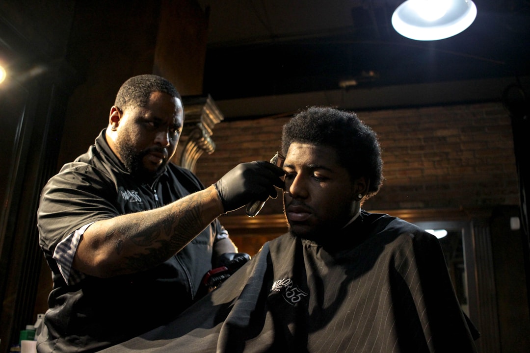 Professional barber performing low fade on Black man