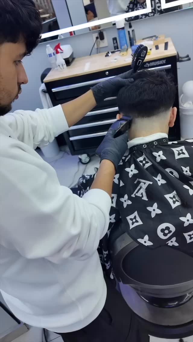 Barber using clippers to blend the back of a haircut
