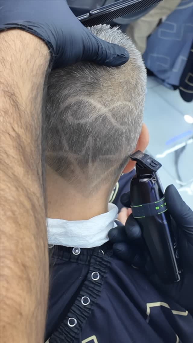 Close-up of a barber trimming hair around an ear